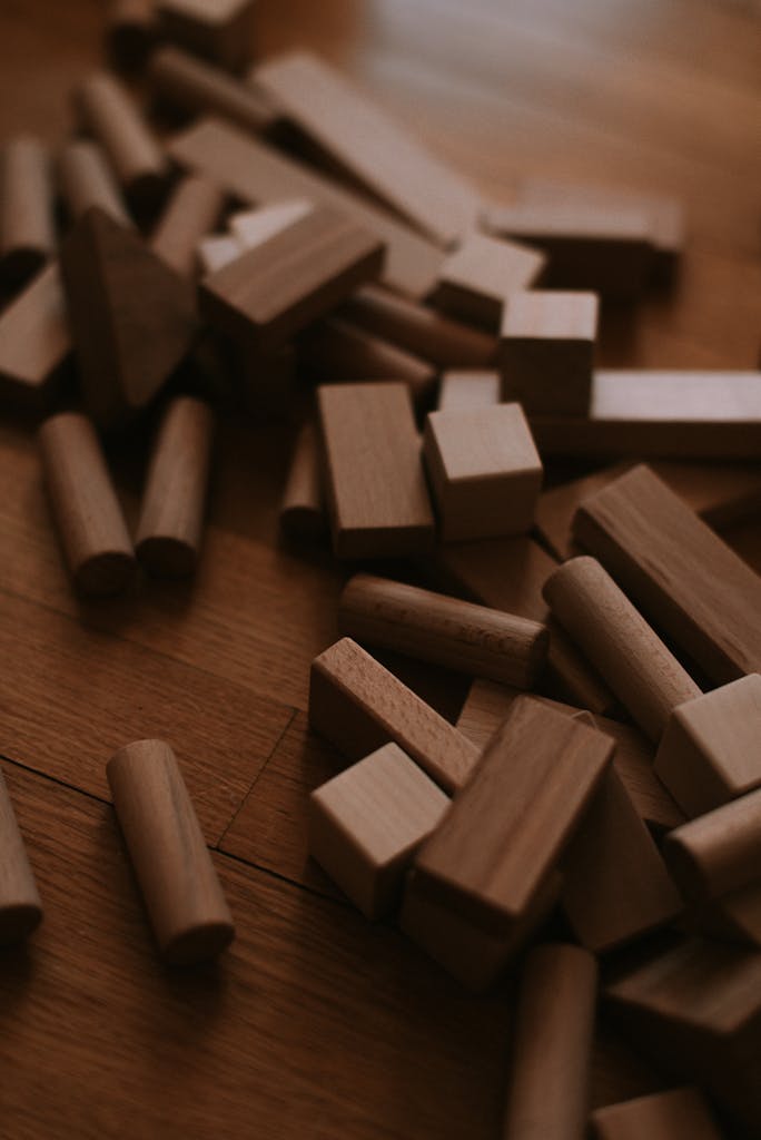 Artistic arrangement of wooden blocks on a warm-toned hardwood floor. Perfect for creative projects.