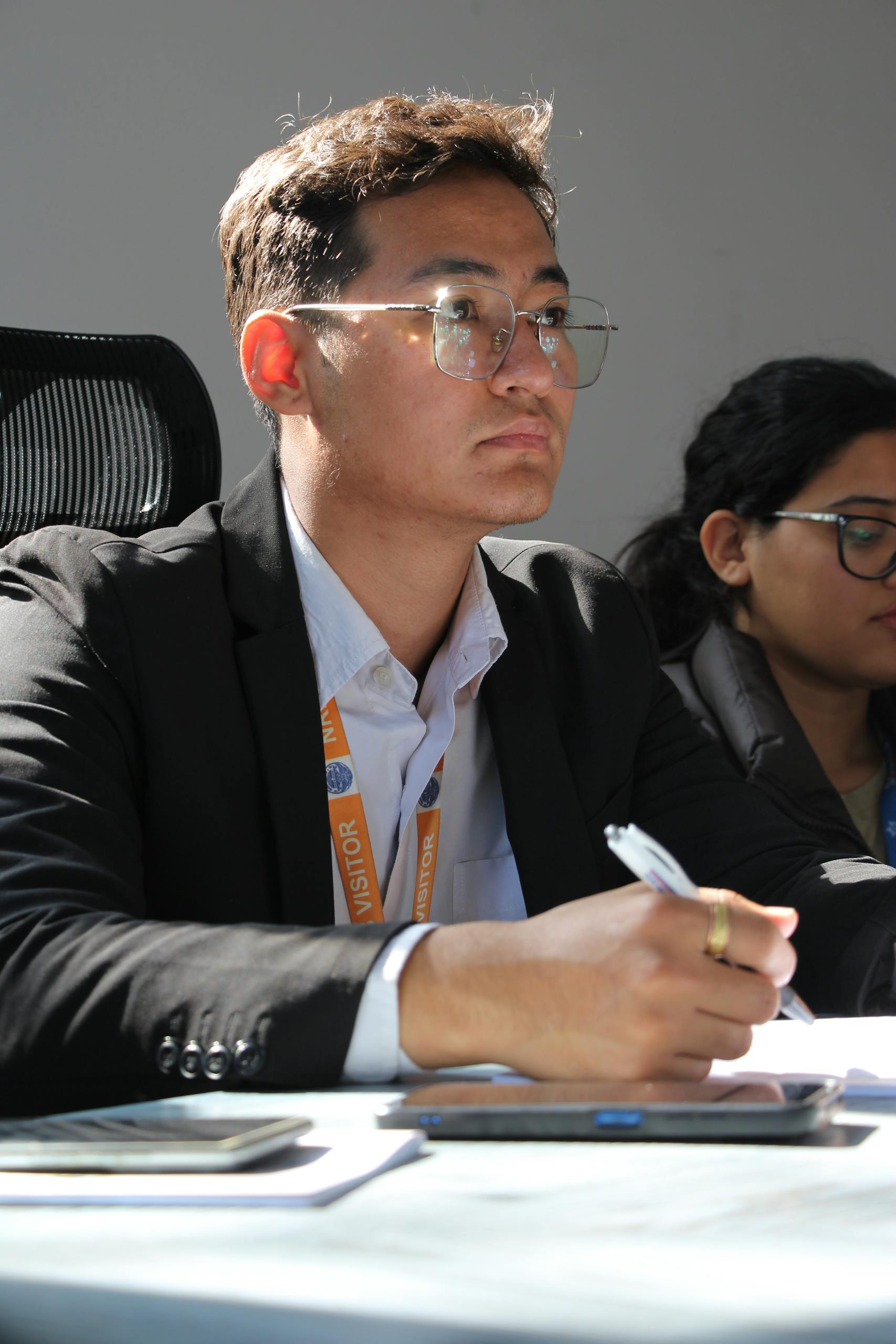 University students attentively participating in a seminar, taking notes and listening closely.